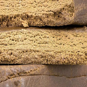 Close-up of Luxus Ketama hash showing smooth pressed structure